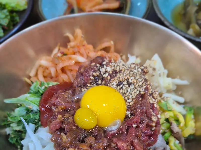 놋그릇에 담긴 육회비빔밥의 클로즈업 샷