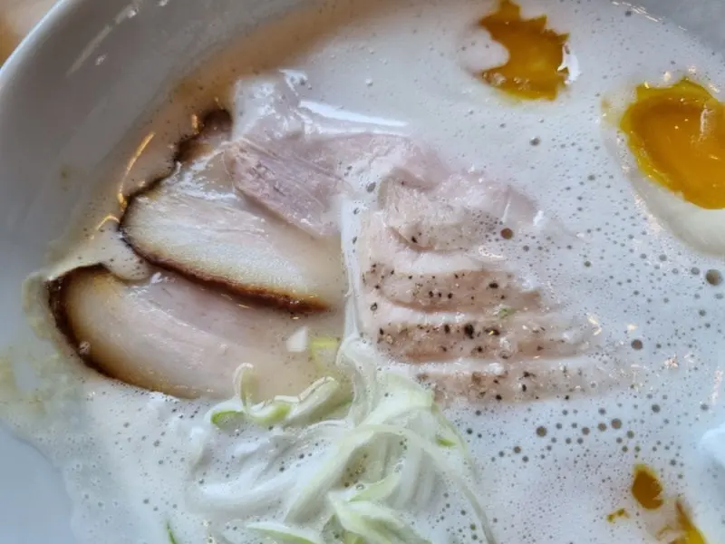 뽀얀 국물에 잠긴 닭고기와 반숙란