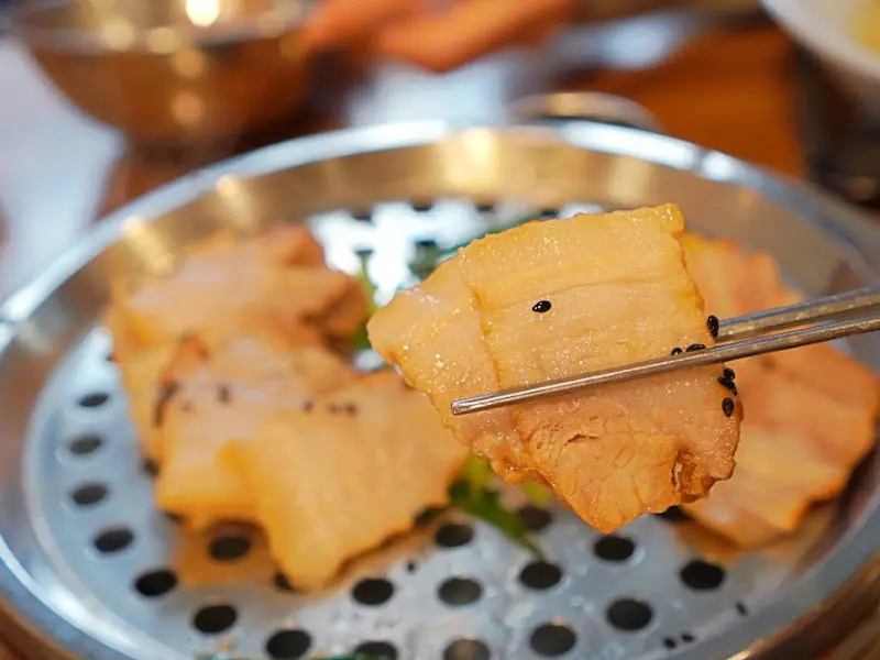 수육을 젓가락으로 집는 모습