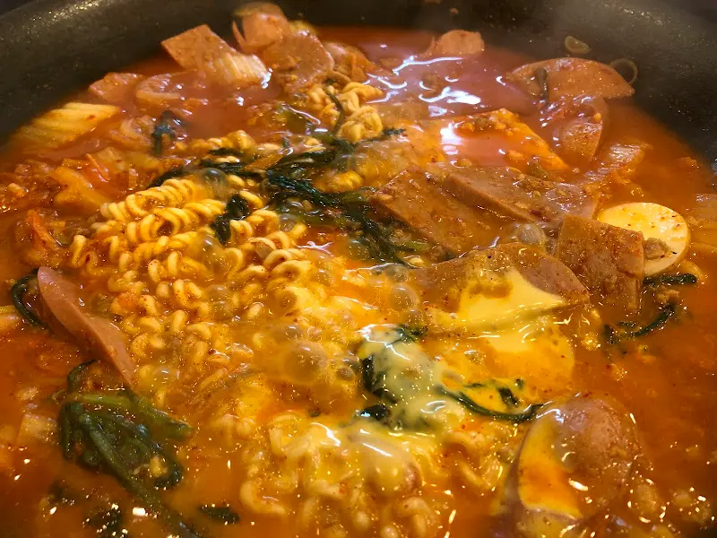 보글보글 끓고 있는 부대찌개의 모습. 햄, 소시지, 라면 사리가 푸짐하게 들어있다.