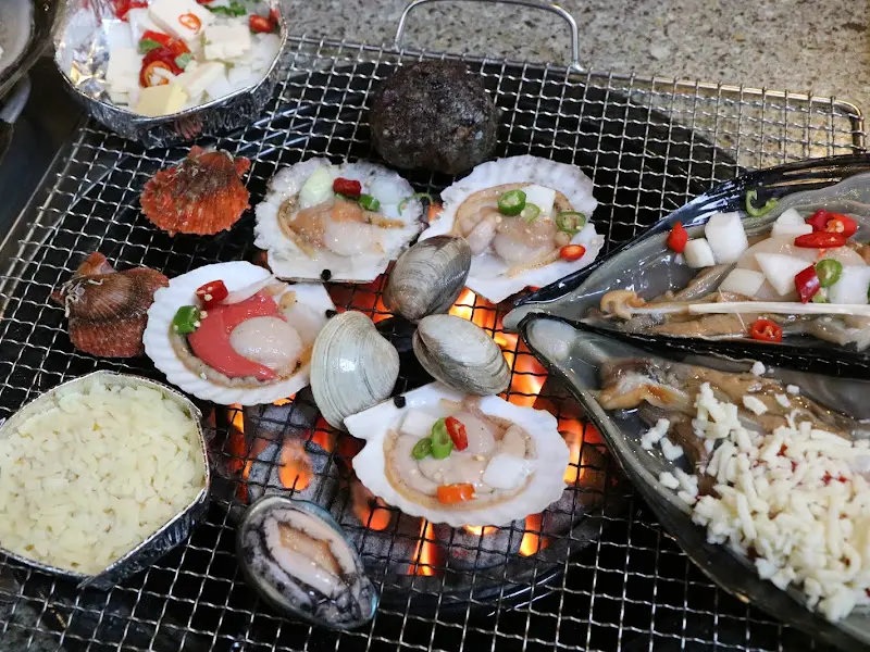 불판 위에 올려진 조개와 해산물