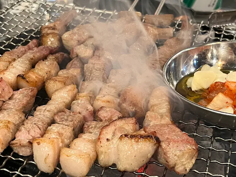 연기가 피어오르는 먹음직스러운 삼겹살