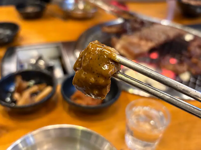 젓가락으로 집어 올린 갈비 한 점