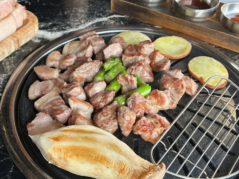 불판 위에 구워진 고기 사진