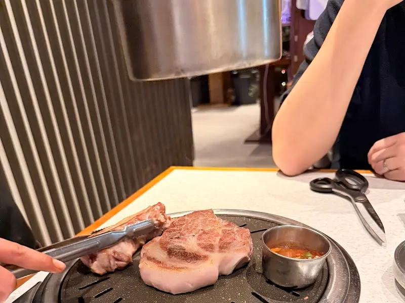 흑돼지를 멜젓에 찍어 먹는 모습