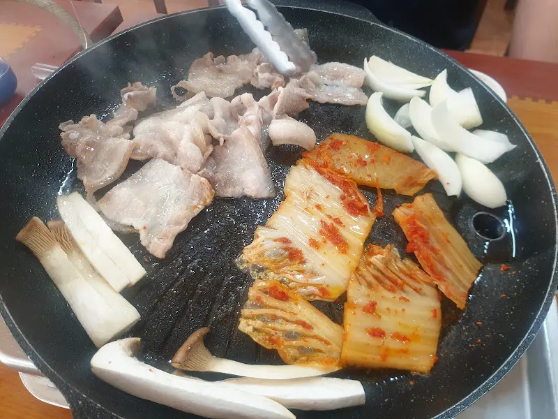 불판 위에서 구워지는 삼겹살과 김치