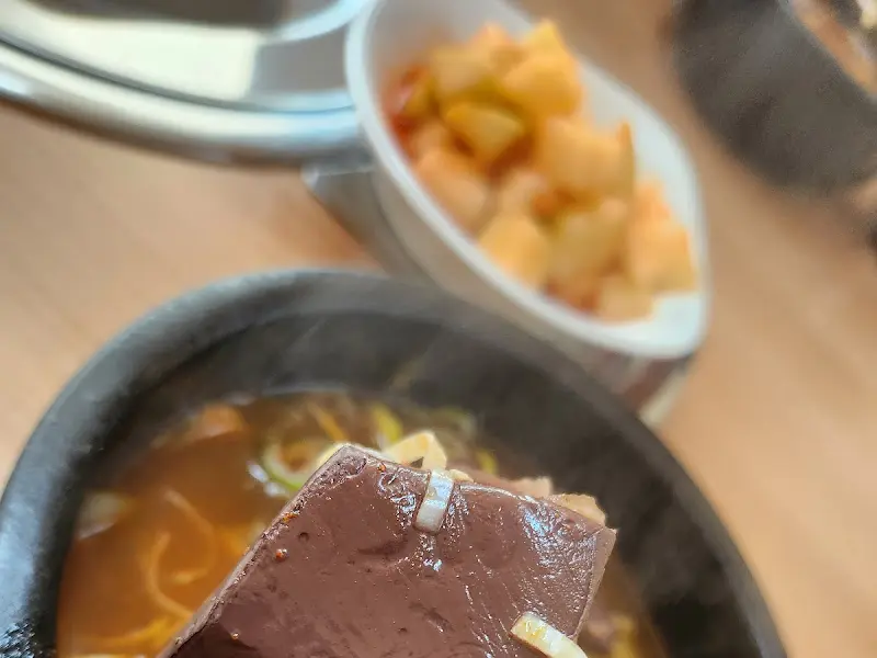 선지해장국 속 큼지막한 선지가 숟가락 위에 올려져 있다.