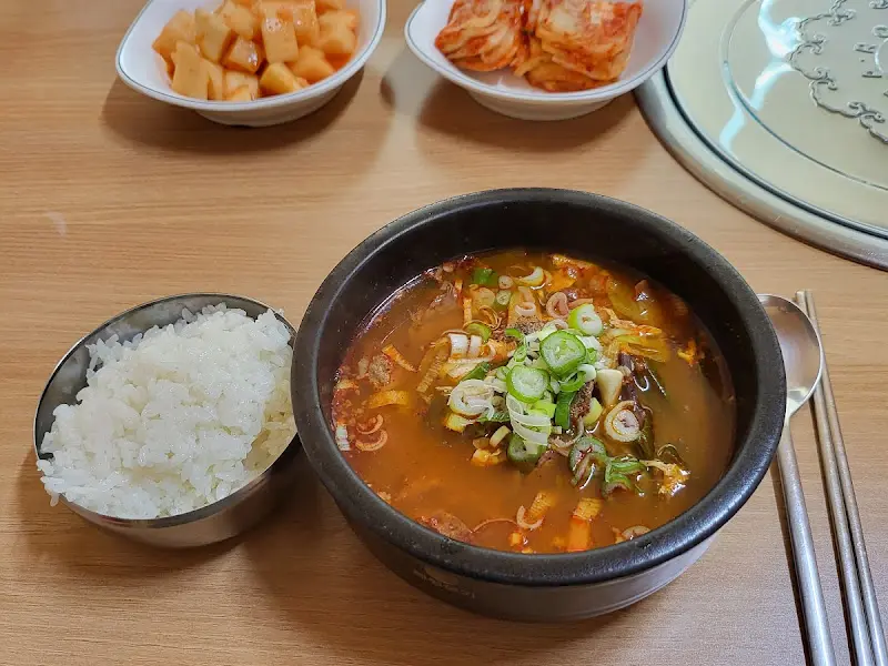 잘 차려진 육개장 한 상의 모습. 깍두기, 김치, 밥과 육개장이 조화롭게 놓여 있다.