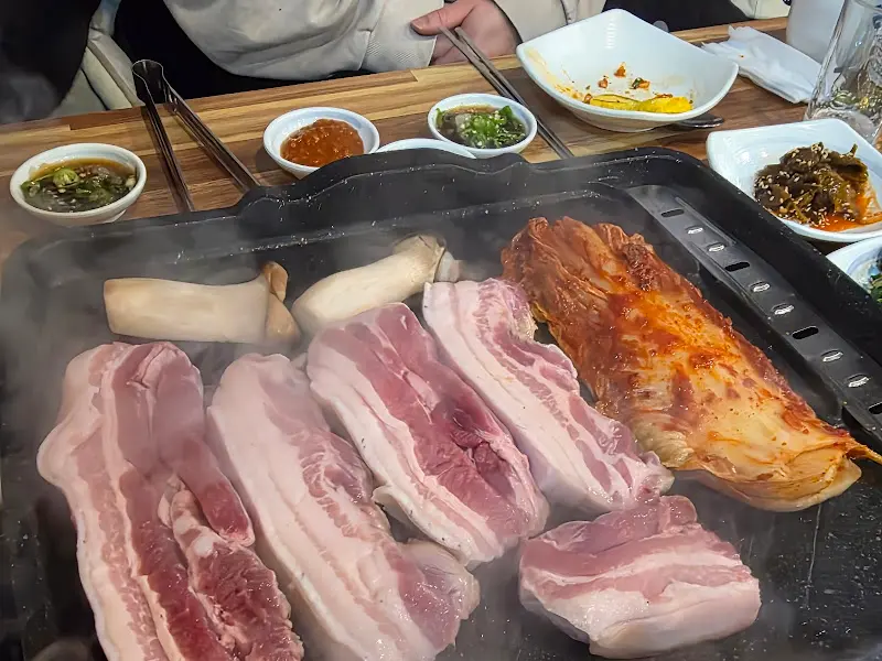 흑돼지 오겹살과 김치가 함께 구워지는 모습