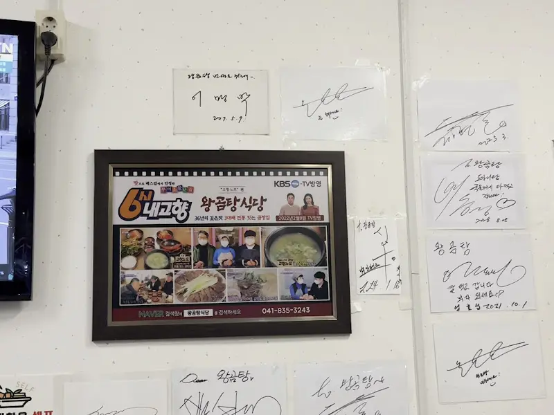 벽에 걸린 방송 출연 사진과 사인