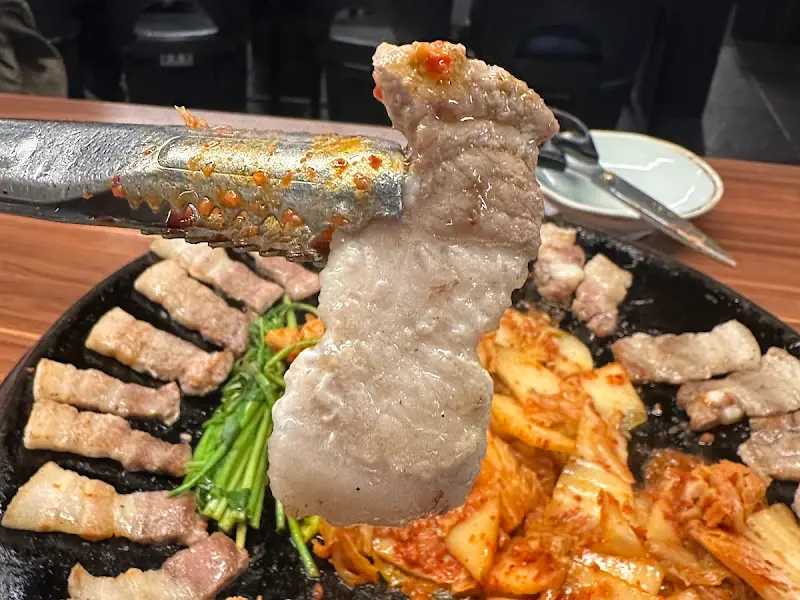 잘 익은 삼겹살을 집어 드는 모습