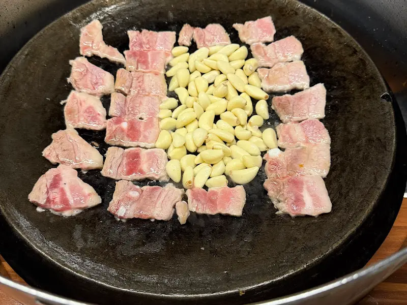 삼겹살과 마늘이 함께 구워지는 모습