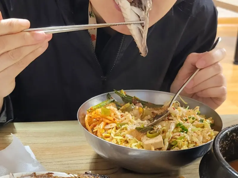 배추생채에 밥을 비벼 고등어구이와 함께 먹는 모습