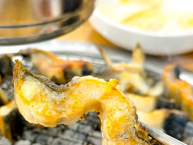 잘 구워진 장어 한 점을 집어 올린 모습