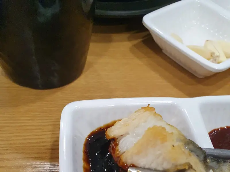 장어 한 점을 소스에 찍어 먹는 모습