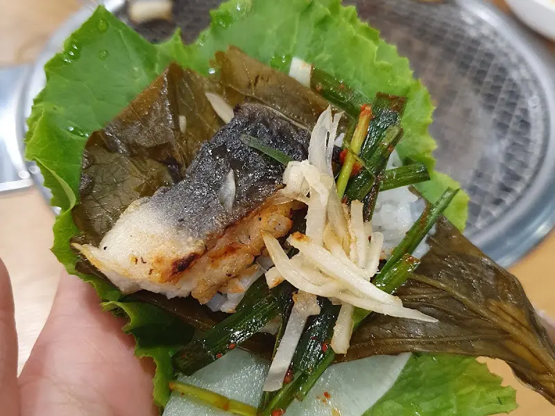 쌈 채소에 장어를 싸 먹는 모습