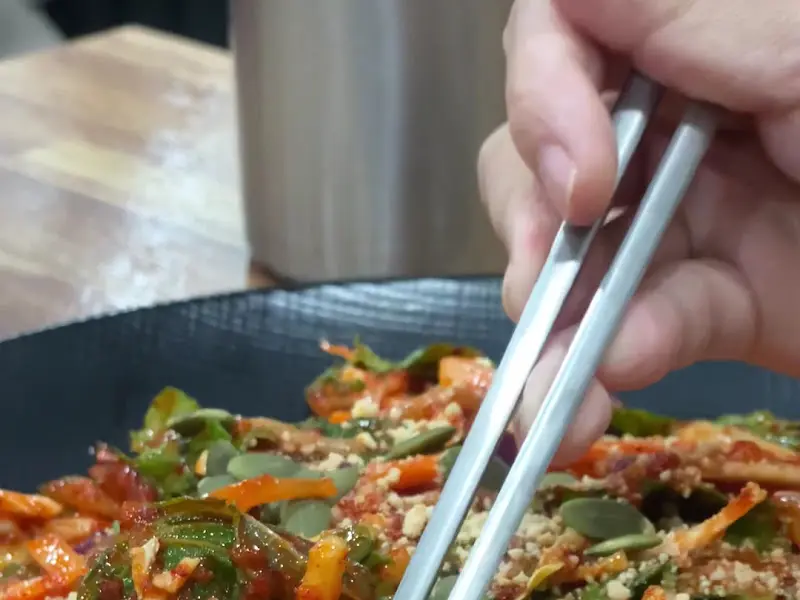 젓가락으로 비빔국수를 들어올리는 모습