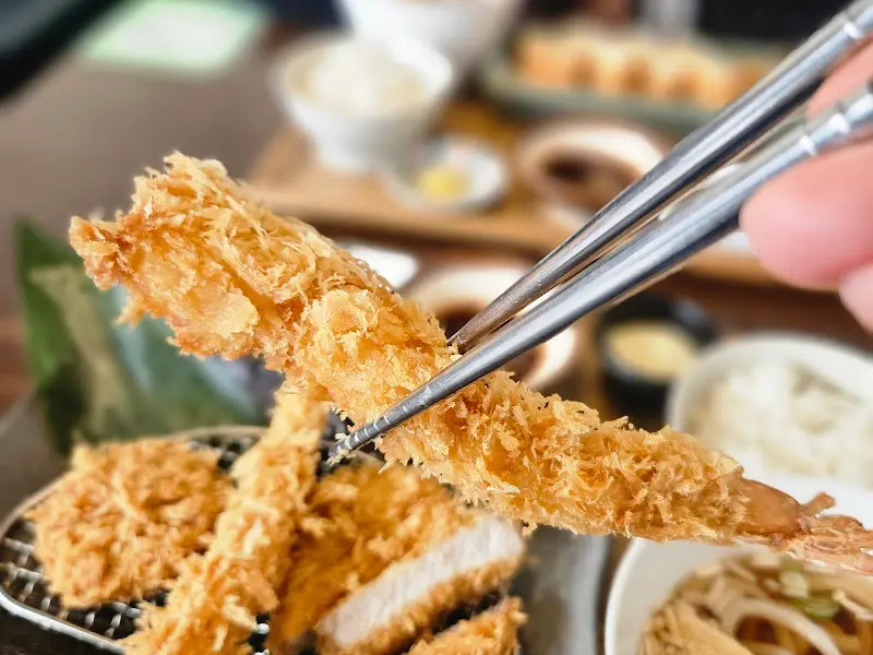 새우튀김을 젓가락으로 집어 올리는 모습