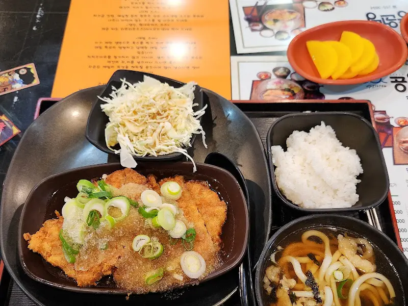 돈까스, 밥, 우동, 샐러드가 한 상에 차려진 모습