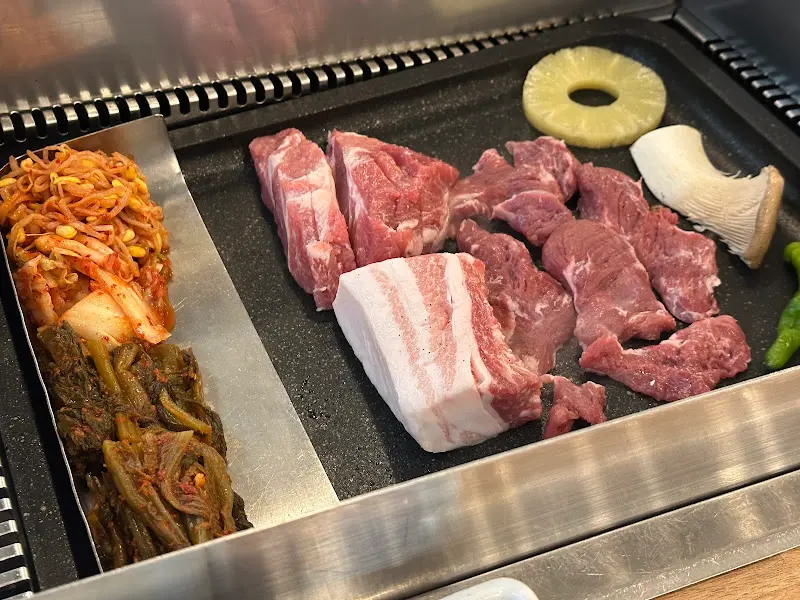 불판 위에 올려진 고기와 갓김치