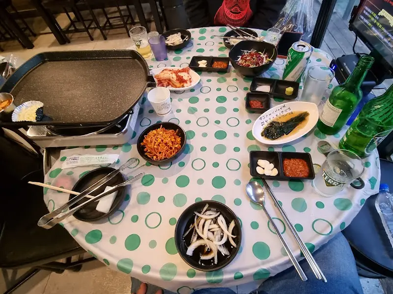 테이블 위에 놓인 삼겹살, 반찬, 볶음밥