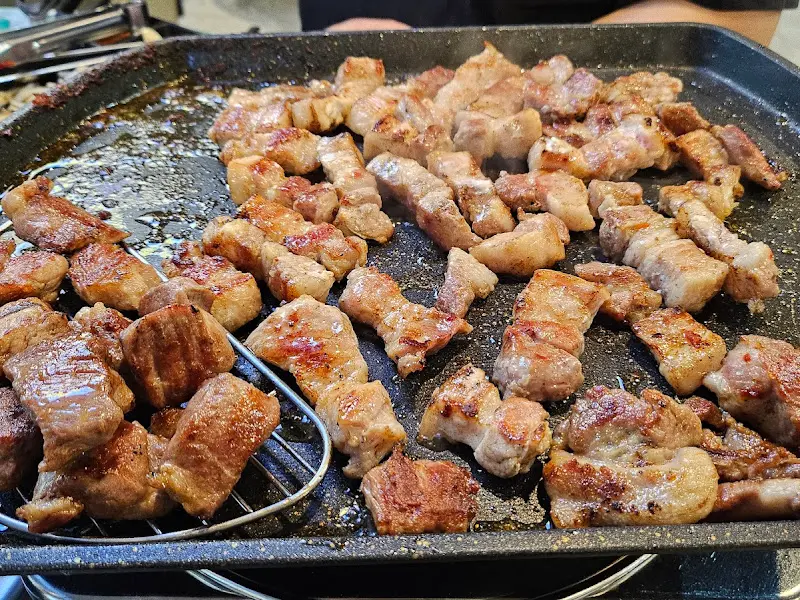 불판 위에서 노릇하게 구워진 삼겹살