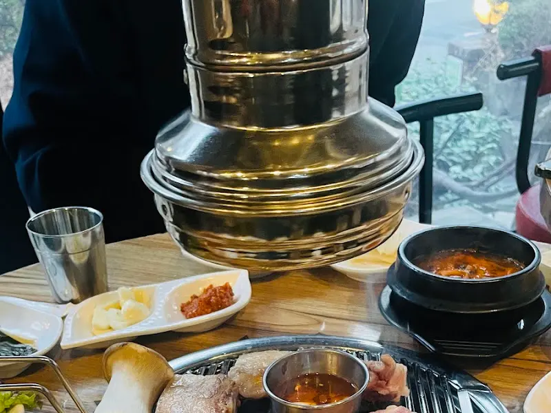 불판 위에 놓인 흑돼지 오겹살과 버섯