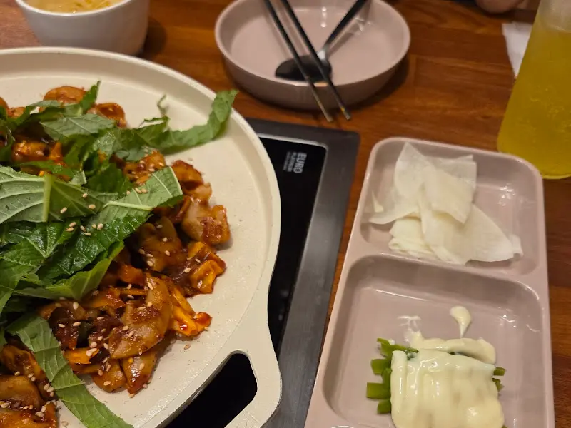 잘 익은 곱창과 곁들임 찬들이 테이블 위에 놓여있는 모습