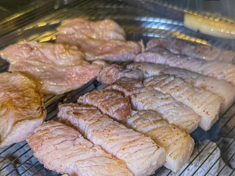 불판 가득 올려진 흑돼지 오겹살과 목살