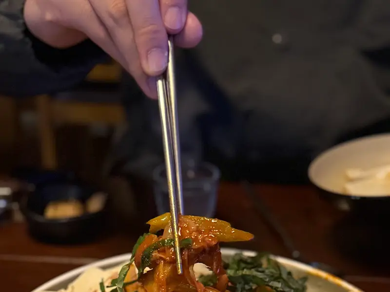 젓가락으로 김치를 집어 올리는 모습