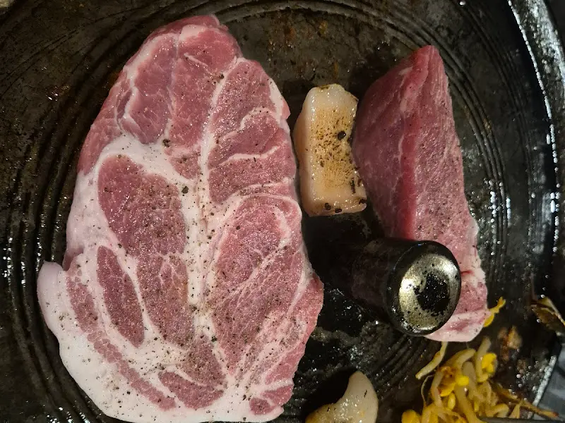 솥뚜껑 위에 올려진 두툼한 돼지고기