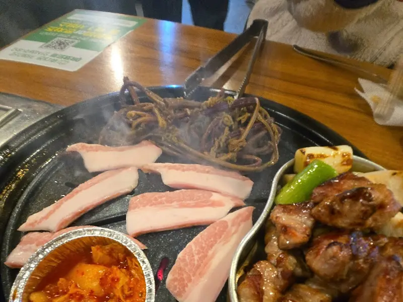 불판 위 삼겹살과 김치