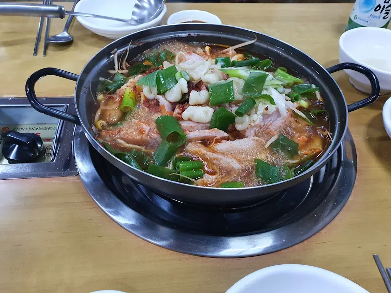 수구리 전골이 테이블 위에서 보글보글 끓고 있는 모습. 뚝배기에 담겨져 나온다.