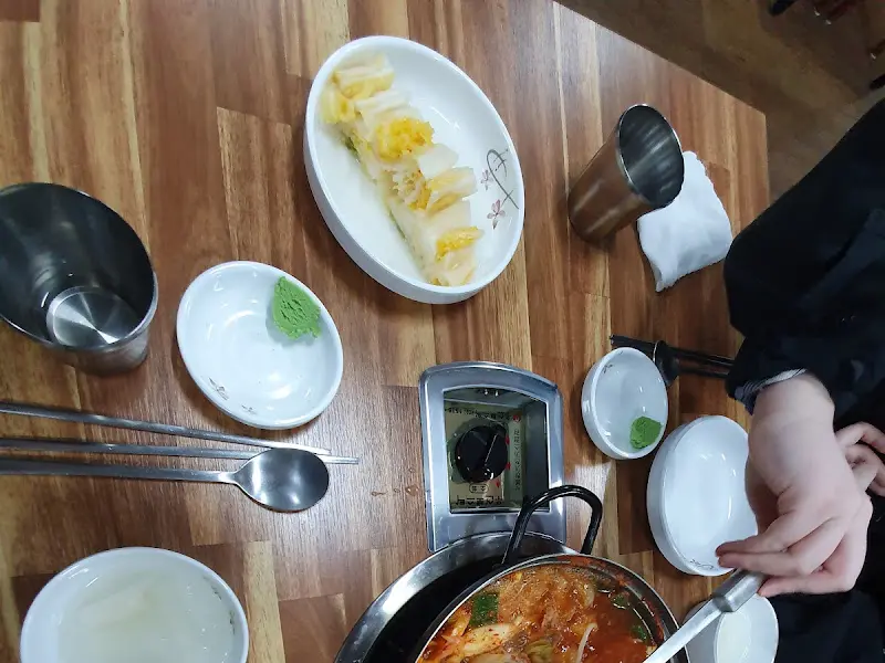 테이블 위에 놓인 반찬과 숟가락, 젓가락 등의 모습. 깔끔하게 세팅되어 있다.