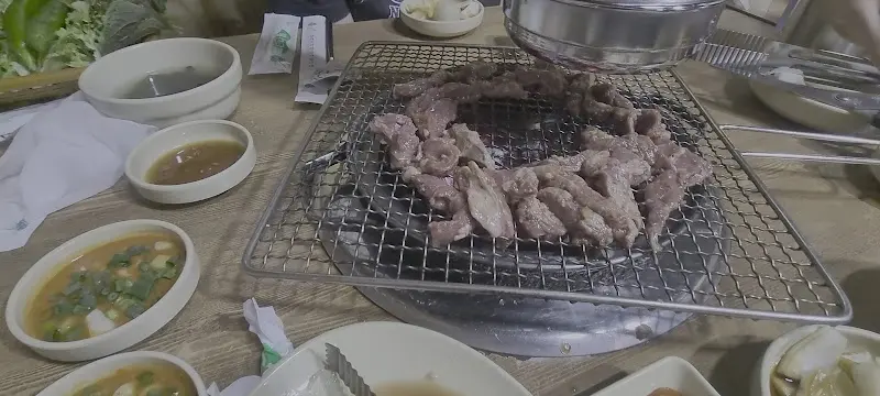 다 익은 갈매기살을 쌈에 싸서 먹는 모습