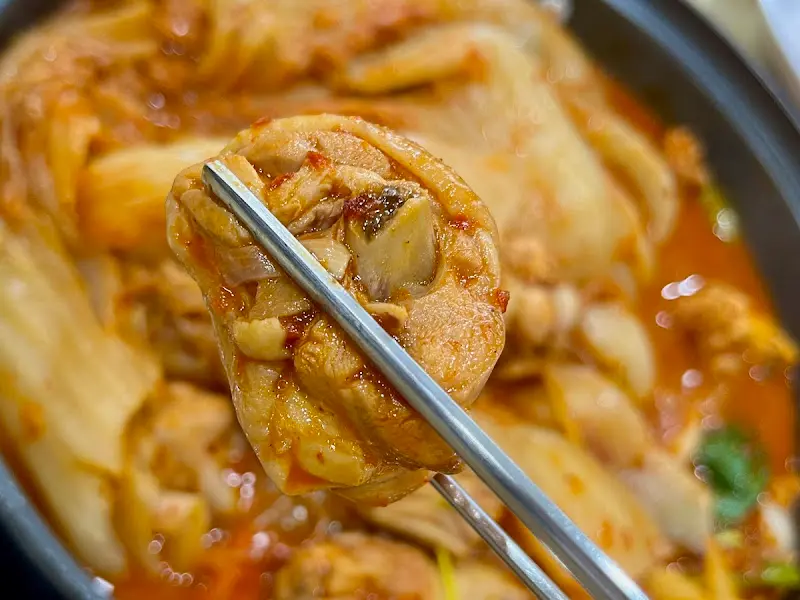 젓가락으로 닭고기를 집어 올리는 모습