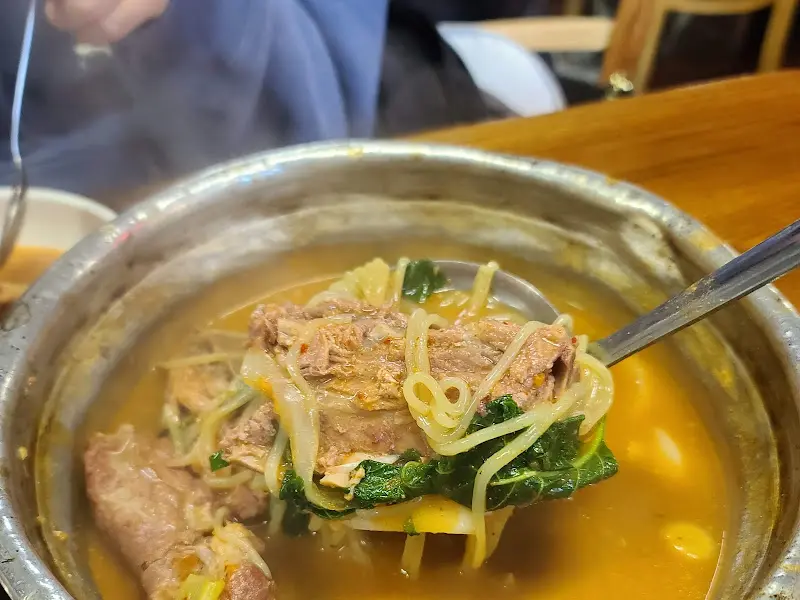 감자탕 국물을 뜨는 모습