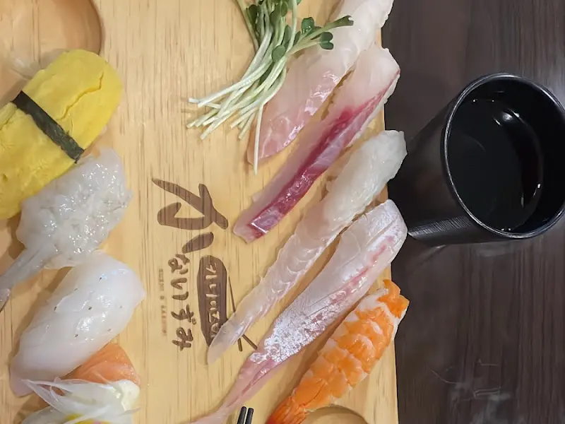 나무 도마 위에 정갈하게 놓인 다양한 종류의 초밥