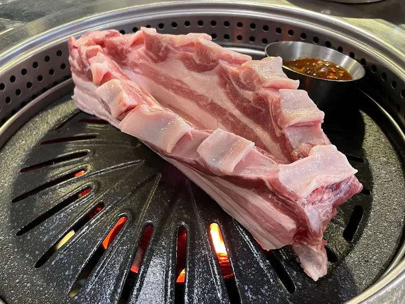 불판 위에 올려진 흑돼지 오겹살