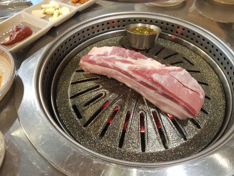 불판 위에 올려진 흑돼지 오겹살