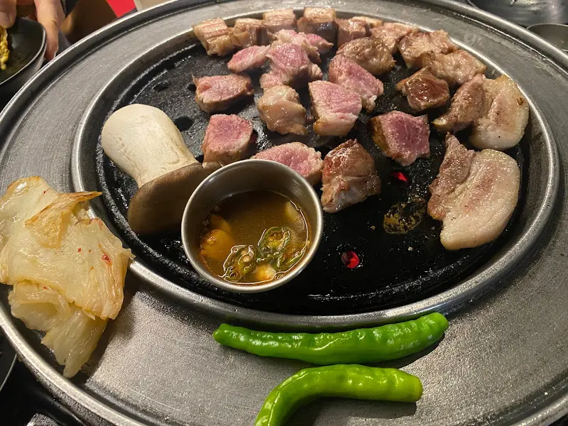 불판 위에서 먹기 좋게 잘린 흑돼지 구이