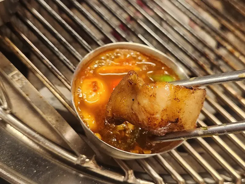 잘 익은 돼지고기를 멜젓에 찍어먹는 모습