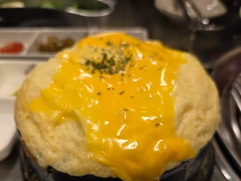 다 익은 돼지고기를 멜젓에 찍어 밥과 함께 먹는 모습