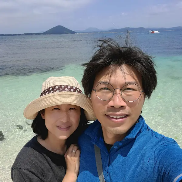 푸른 바다를 배경으로 환하게 웃고 있는 커플의 모습