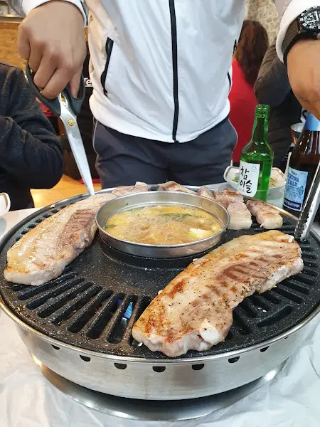 불판 위에서 맛있게 구워지고 있는 삼겹살