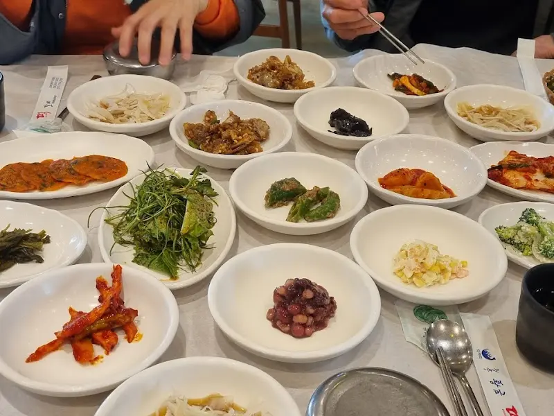 다양한 종류의 밑반찬이 가득 차려진 테이블