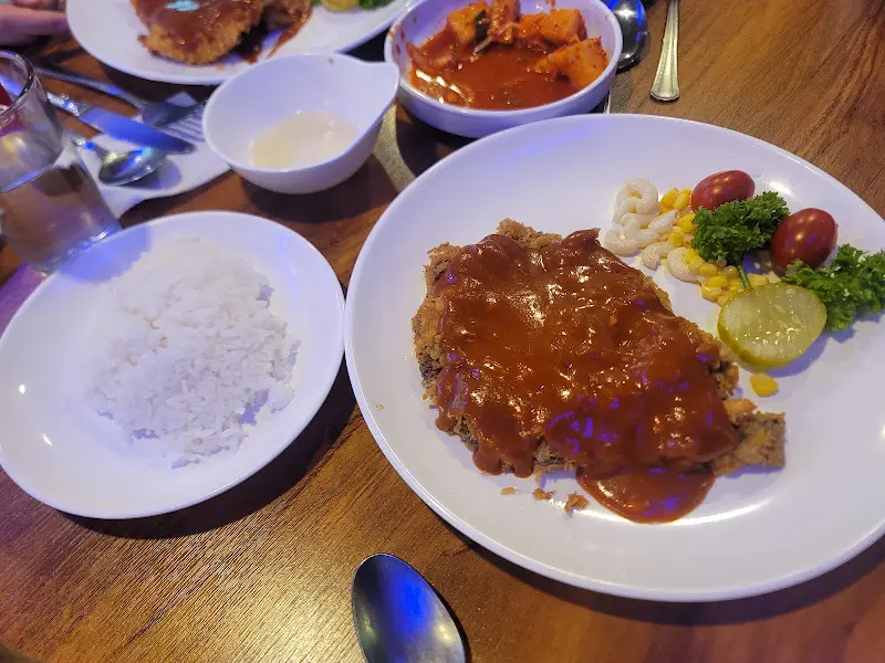 돈까스, 밥, 깍두기, 샐러드가 차려진 테이블