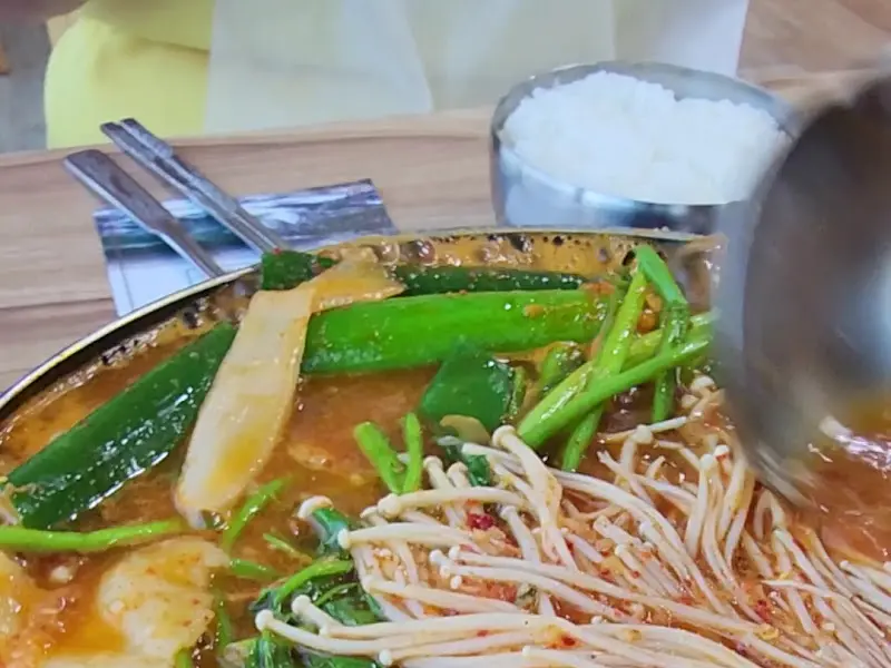 메기 매운탕을 덜어먹는 모습, 국물이 진하고 얼큰해 보인다.