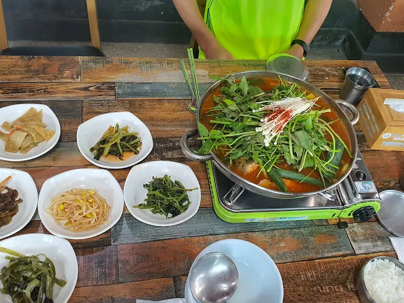 테이블 전체 샷, 푸짐한 매운탕과 밑반찬이 한 상 가득 차려져 있다.