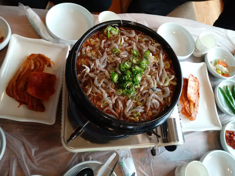 테이블 위에서 보글보글 끓고 있는 매운탕의 모습. 다양한 채소와 함께 메기가 듬뿍 들어있다.